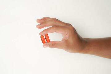 Male hand holding soft gels, Fish oil capsules, omega 3, omega 9, vitamin D, vitamin E, supplements
