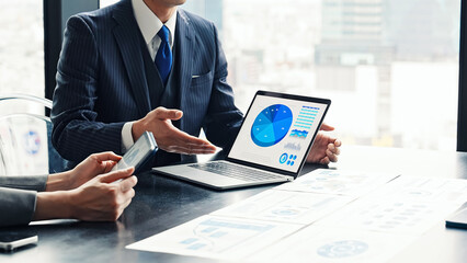 オフィスでPC画面を見ながら面談するビジネスパーソンのグループ