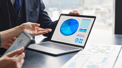 A group of business people having a meeting in an office while looking at a computer screen