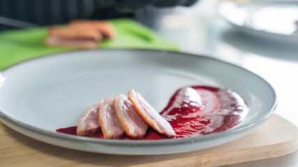 The chef places the duck on cranberry sauce. 