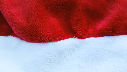 Red and white Christmas santa hat fleece fabric. Soft textile texture background © Beto