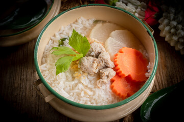 Pork congee and jasmine flowers are placed on the dining table. Retro Thai style image.