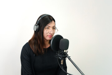 Beautiful asian woman (LGBTQ) is a singer. She enjoying sing a song or karaoke in music studio with microphone condenser and headphones for fun or voice creative