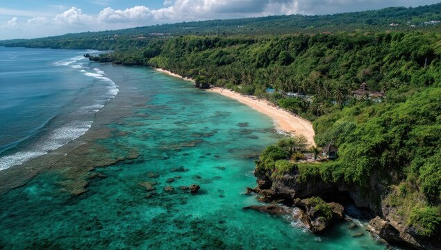 Coastal paradise a turquoise sea meets a sandy beach, fringed by lush green trees atop rocky cliffs on a sunny day