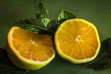 A two pieces of a lemon on the dark green background