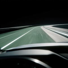 Obraz premium Night-time highway driving; blurred motion, pale green lines mark a curving road ahead, dark surroundings