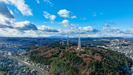 青空の現代都市と電波塔のドローン空撮