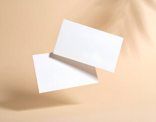 Elegant business card mockup with two blank cards hovering mid-air on a pastel cream gradient backdrop with a soft plant shadow.