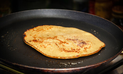Golden Pancake Being Cooked in a Black Nonstick Pan