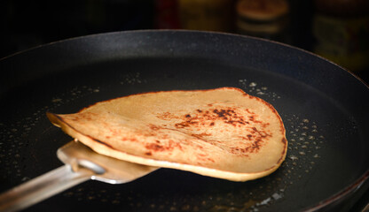 Golden Pancake Being Flipped in Frying Pan for Delicious Breakfast Treat