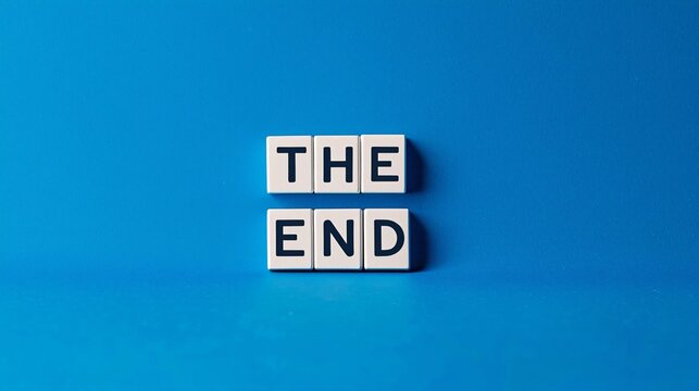 A conceptual photograph with a solid blue background, featuring white letter blocks arranged to spell out "THE END",evoking a visual metaphor of a conclusion or final action