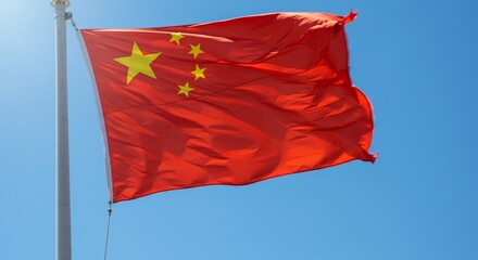 China national flag. The patriotic red national flag of China waves against a clear blue sky, a powerful emblem of the Asian republic