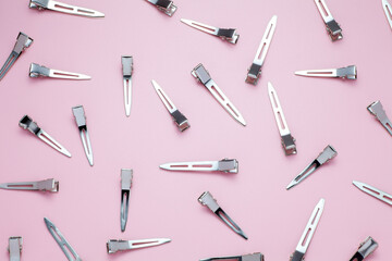 Many metal hairpins on a pink background