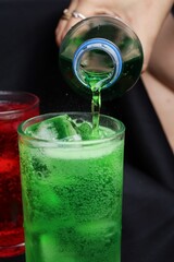 Pouring  soft drink and ice in glass