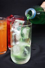 Pouring  soft drink and ice in glass
