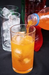 Pouring  soft drink and ice in glass