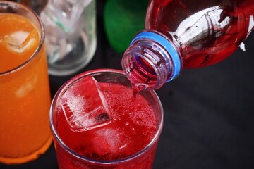 Pouring  soft drink and ice in glass