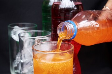 Pouring  soft drink and ice in glass