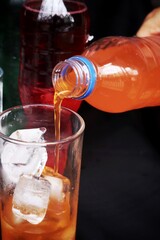 Pouring  soft drink and ice in glass