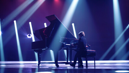 a pianist plays the piano on stage at a concert
