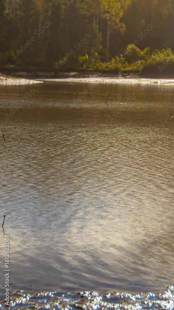 Poster timelapse shot capturing reflection of movement of clouds on lake water surface during daytime. vert