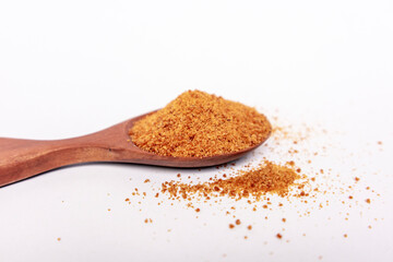 Top view of palm sugar in a wooden spoon isolated on white. brown coconut palm sugar.