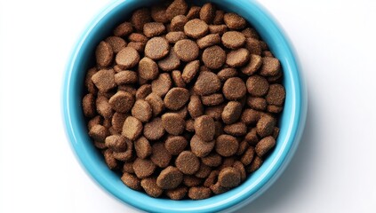 Obraz premium A blue ceramic bowl overflows with brown, circular kibble pellets on a bright white surface, seen from above, with simple lighting and clean presentation