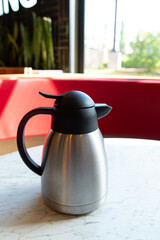 Stainless Steel Thermos on Marble Table in Café Interior