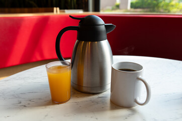 Coffee, Orange Juice and Thermos on Marble Table in Café Setting