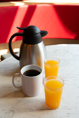 Coffee, Orange Juice and Thermos on Marble Table in Café Setting