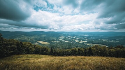 High-angle view of a valley nestled amidst forested mountains under a partly cloudy sky