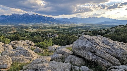 Mountain vista from rocky outcrop.  Vast valley,  rolling hills, and distant peaks