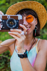 Charming woman with camera on the street. Portrait of a beautiful girl smiling on the street....