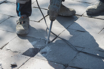 Workers repairing pavement in urban area during day