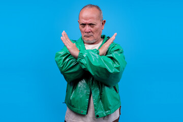 Senior Asian Male Crossing Arms Showing Stop Gesture Isolated On Blue Background