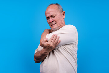 Older Asian Man Grimaces And Clutches His Elbow Indicating Joint Pain Or Discomfort