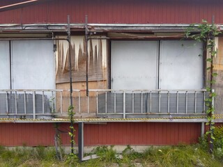 はがれた板壁と雨戸の閉まったままの空き家