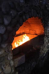 Burning fire in the fireplace. Wood logs. Cozy warm fireside. Brick oven