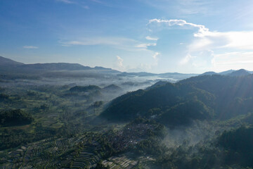 Misty Valley with Rice Terraces Surrounded by Mountains at Dawn