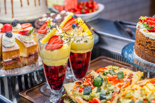 Full dessert tray with ice cream sundays in tall glass and cake on display