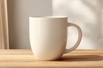 Empty white ceramic coffee mug with smooth glossy finish and curved handle on wooden surface with soft natural light in background