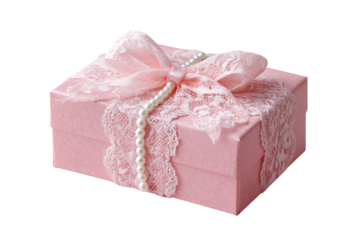 Pink gift box adorned with delicate lace and pearls.  A  pale pink box, rectangular, presents a  light pink lace ribbon with a bow atop.  A string of pearls runs along the ribbon