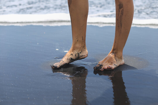Woman’s Legs on Black Sand Beach by the Ocean - Powered by Adobe