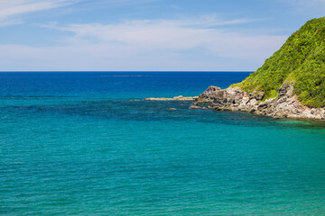 澄んだエメラルドブルーの海と岩場の風景