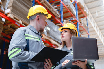 Confident workers with clipboard and laptop discuss inventory strategy in smart warehouse environment, surrounded by organized packaging materials.
