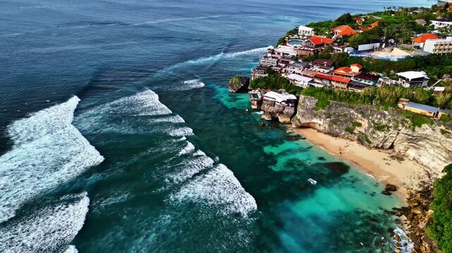 Coastal surfers resort with wavy sea in Indonesia, aerial view