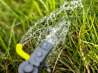 Watering the lawn with a sprinkler on a sunny day	
