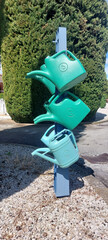 watering cans stacked on a metal stand available for people to water the plants and flowers at the...