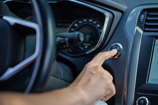 Close-up of hand pressing start button to turn on car engine. Keyless ignition system in modern car