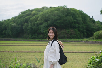 畑を背景に微笑む女性